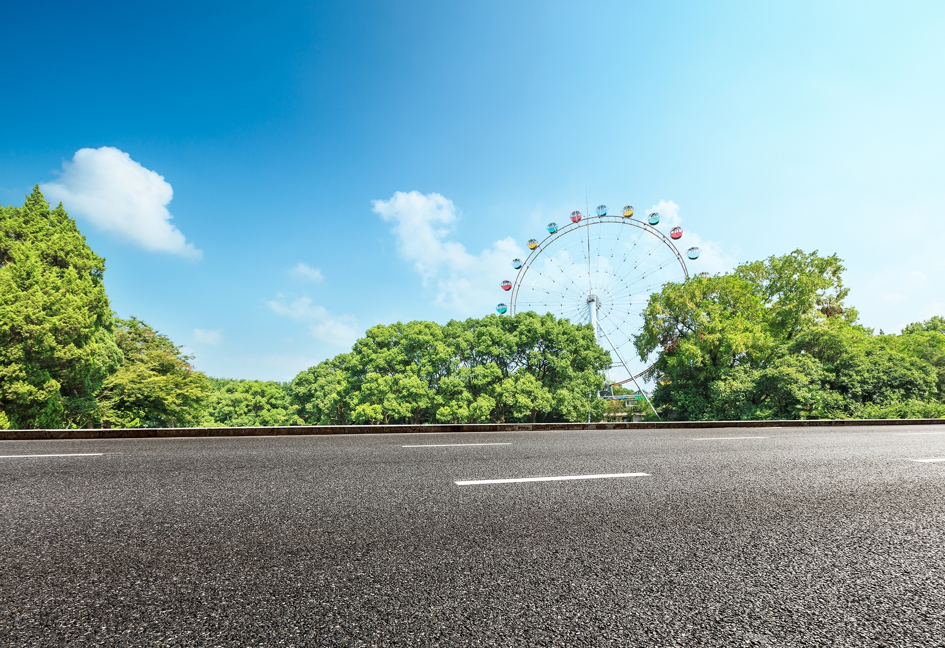 asphalt-road-and-forest-with-playground-ferris-whe-2026-01-11-09-09-57-utc 1